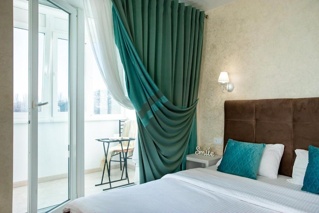um quarto com uma cama e uma cortina verde em Студия Luxury в центре em Mykolaiv