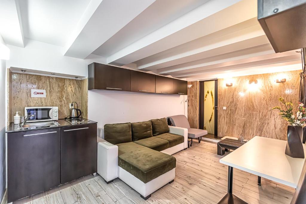 a living room with a couch and a kitchen at Modern Apartment in Piata Sfatului in Braşov