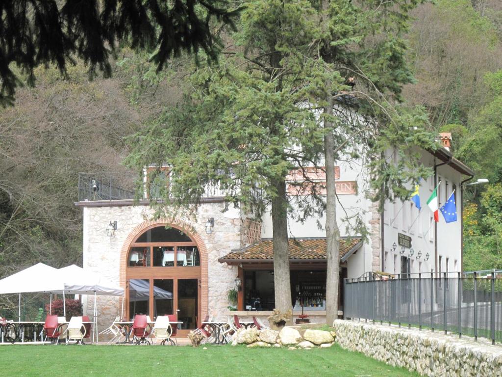 a building with a table and chairs in front of it at Locanda Al Confin - Osteria Le Piere in Pigozzo