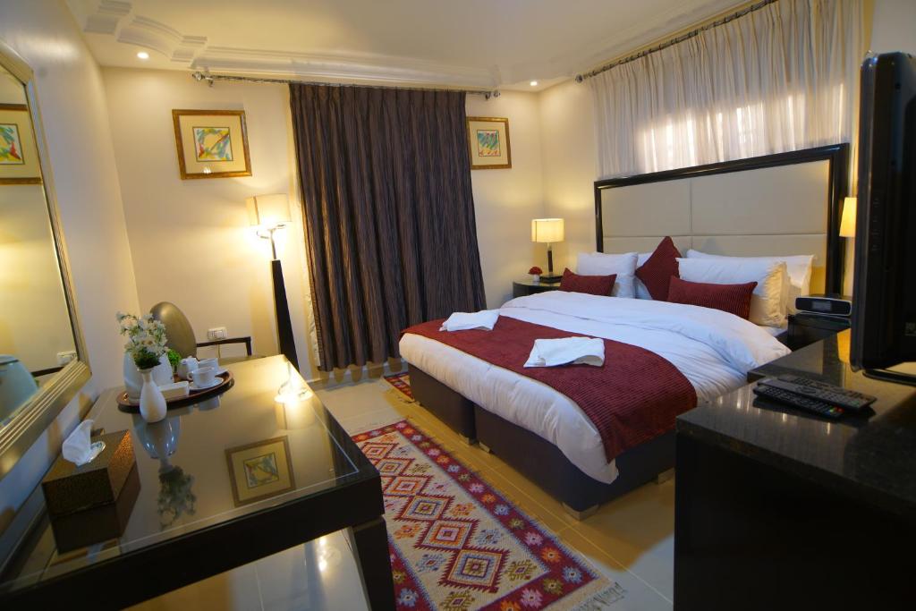 a hotel room with a large bed and a desk at Over Mountains Hotel in Wadi Musa