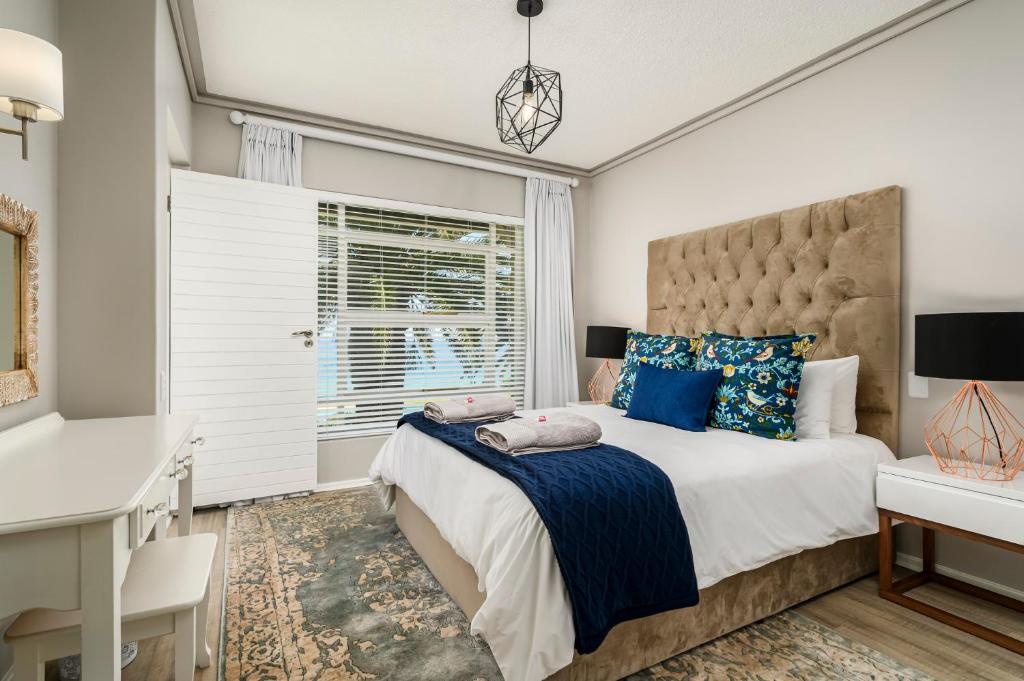 sypialnia z dużym łóżkiem i biurkiem w obiekcie Brookes Hill Suites Luxury Apartment 124 w mieście Port Elizabeth