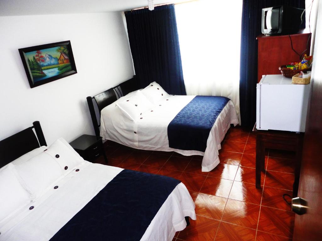 una habitación de hotel con 2 camas en una habitación en Hotel Casa Sarita, en Bogotá