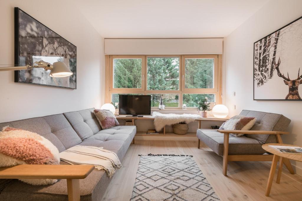 a living room with a couch and a tv at Airoto by Totiaran in Baqueira-Beret
