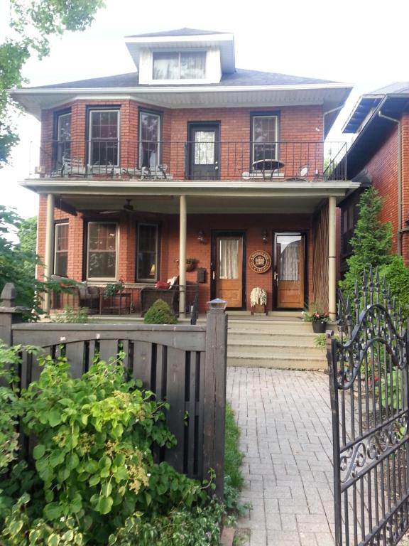 a house with a fence and a dog on the porch at A Hidden Gem Bed and Breakfast in Windsor