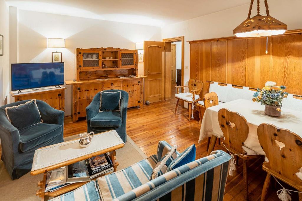 een woonkamer met blauwe stoelen en een tafel bij Villa Radiosa - Stayincortina in Cortina dʼAmpezzo