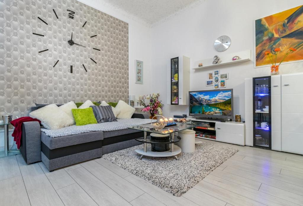 ブダペストにあるGrey Orchid Apartment - studioのリビングルーム(ソファ、壁掛け時計付)