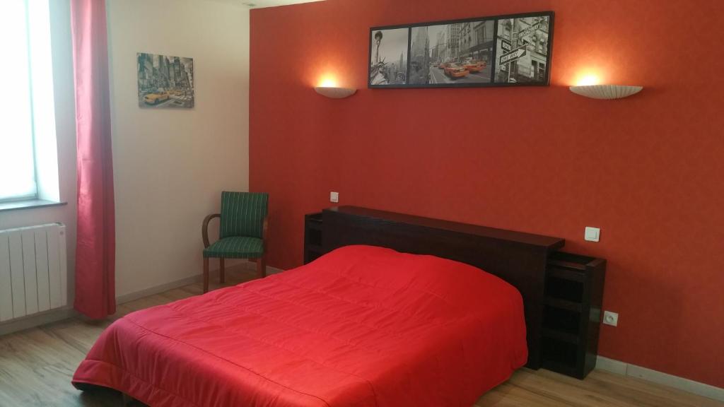 Un dormitorio rojo con una cama roja y una silla en La Roseraie, en Épinal