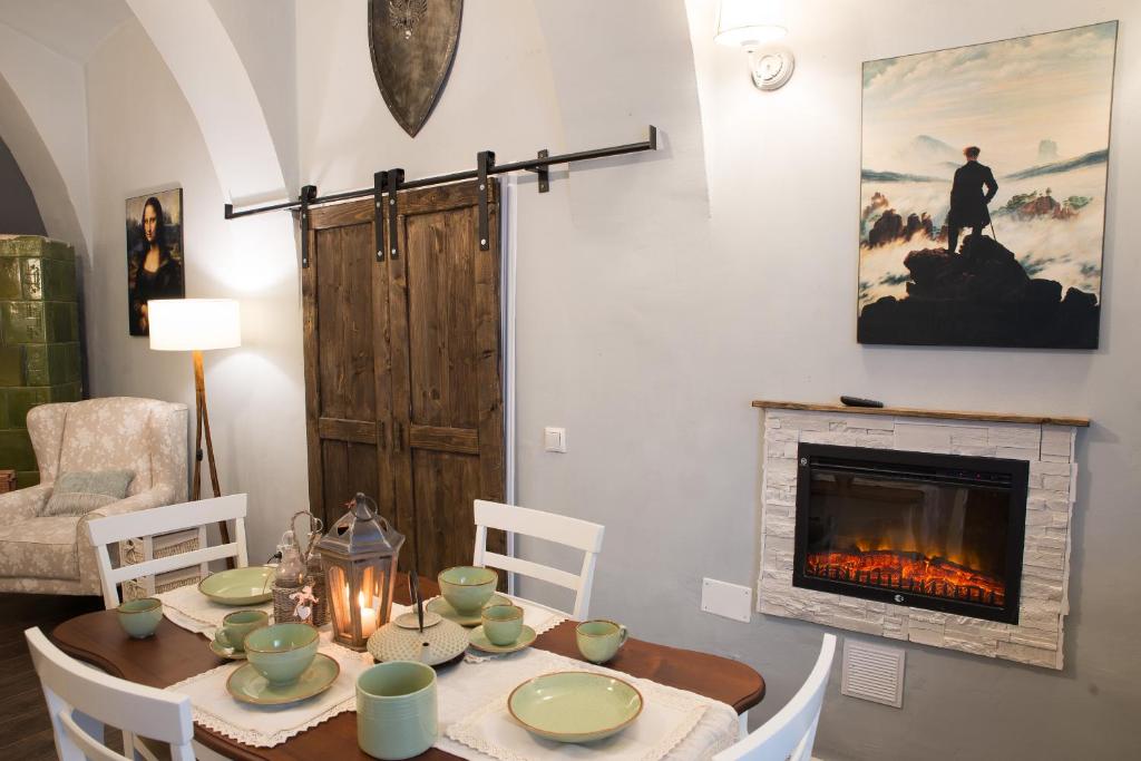 a dining room with a table and a fireplace at Ultra central medieval apartment in Cluj-Napoca