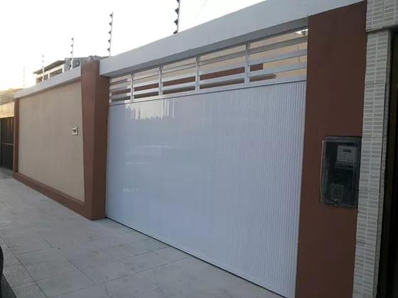 a building with a white garage door on it at CASA DE TEMPORADA in Aracaju