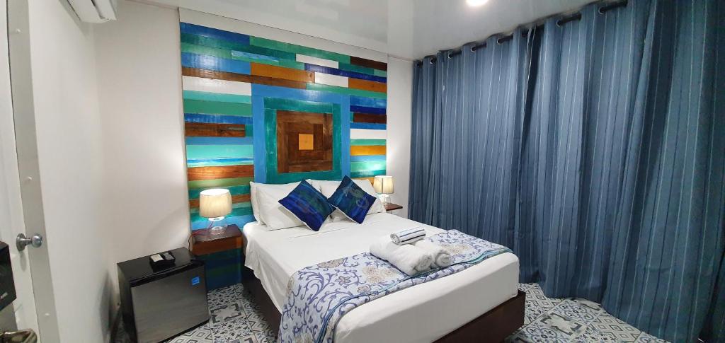 een slaapkamer met een bed met een schilderij aan de muur bij Olas Del Caribe in San Andrés