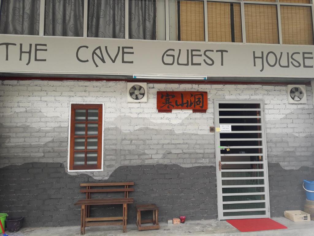 a building with a sign that reads the give guest house at The Cave in Tanah Rata