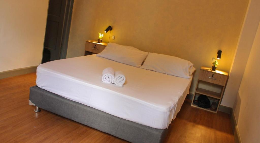 a bedroom with a bed with two white towels on it at La Vaina Cali in Cali