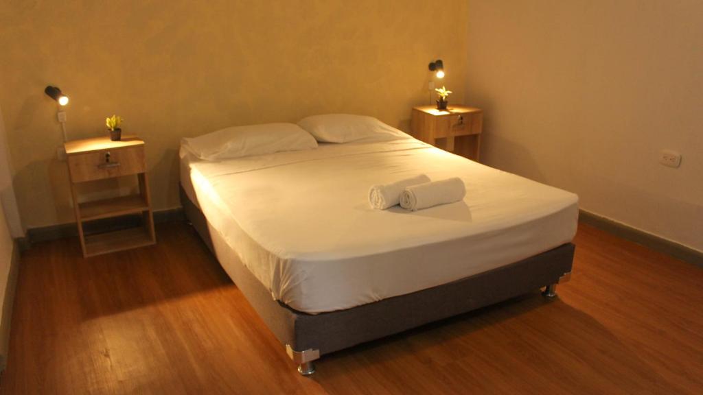 a bedroom with a bed with two nightstands and two lights at La Vaina Cali in Cali