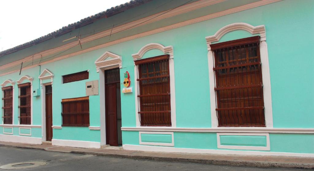 a blue and white building with brown windows at La Vaina Cali in Cali