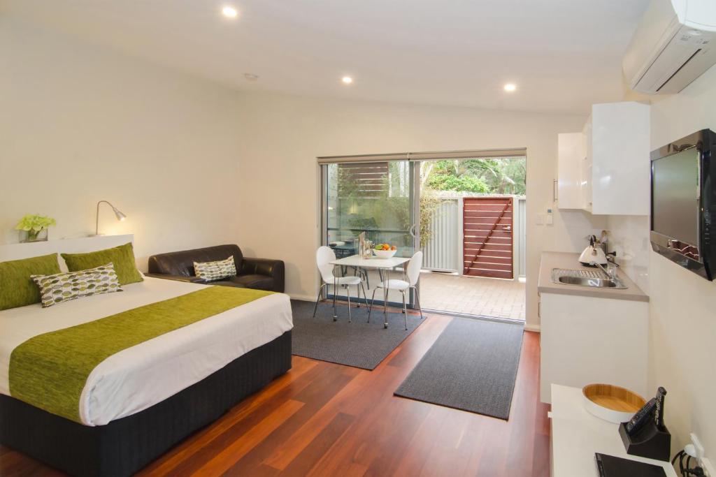 a bedroom with a bed and a kitchen with a table at Margaret River Beach Studios in Margaret River Town