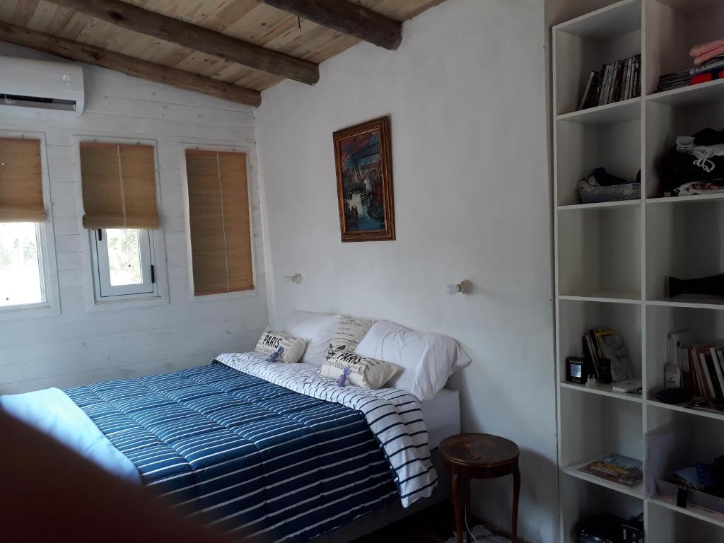 1 dormitorio con cama y estante para libros en La Maison De Valerie, en Punta del Diablo