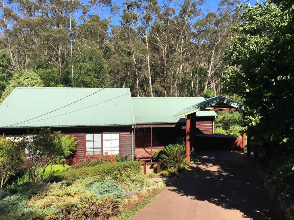 a house with a green roof and a driveway at Bluebell Cottage in Leura