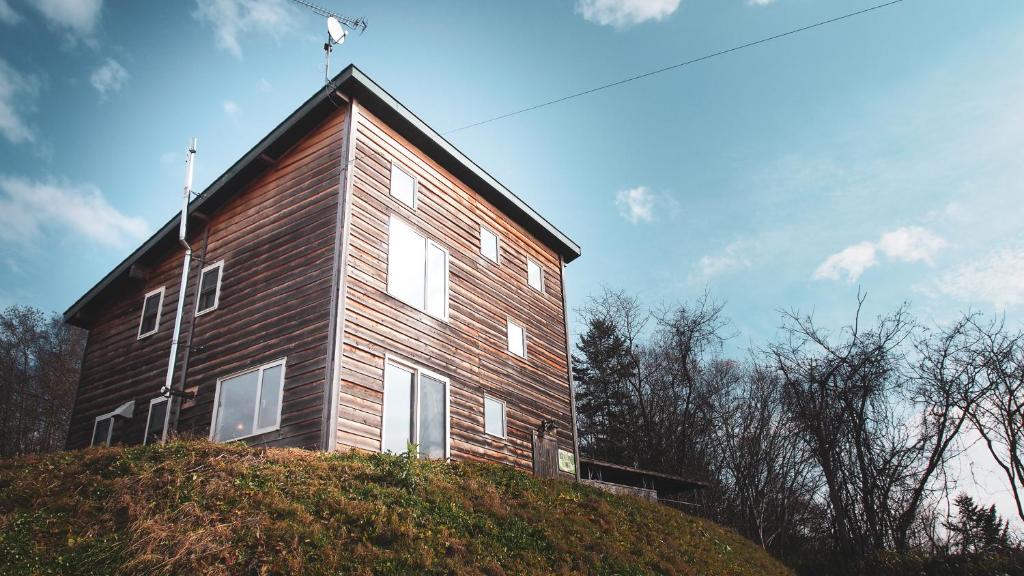 una casa de madera en la cima de una colina en Guest House ONLY ONE en Niseko