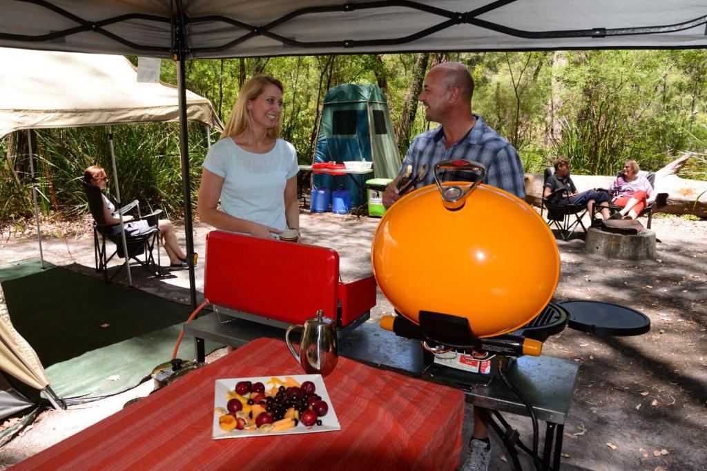 a man and a woman standing under a tent at WA Wilderness - one step from nature in Pemberton