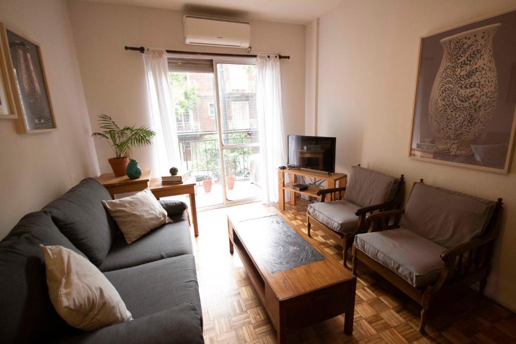 sala de estar con sofá, sillas y TV en Departamento en Belgrano en Buenos Aires