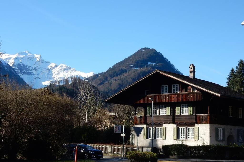 a house with a mountain in the background at New renovated flat in protected chalet in Interlaken