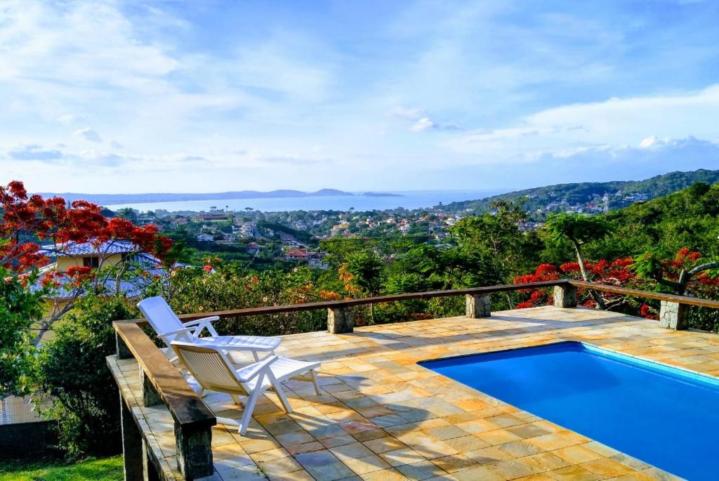 una terraza con una silla y una piscina en Marola’s Búzios en Búzios
