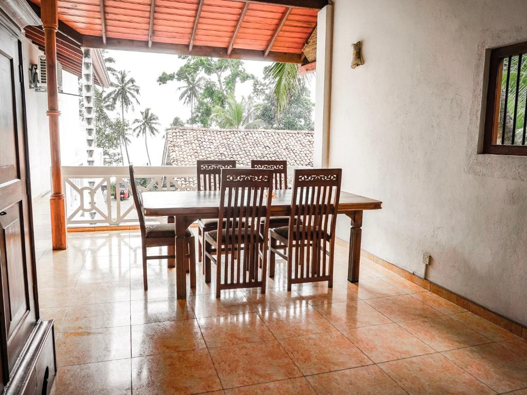 a dining room with a wooden table and chairs at Nuga Eden Tangalle in Tangalle