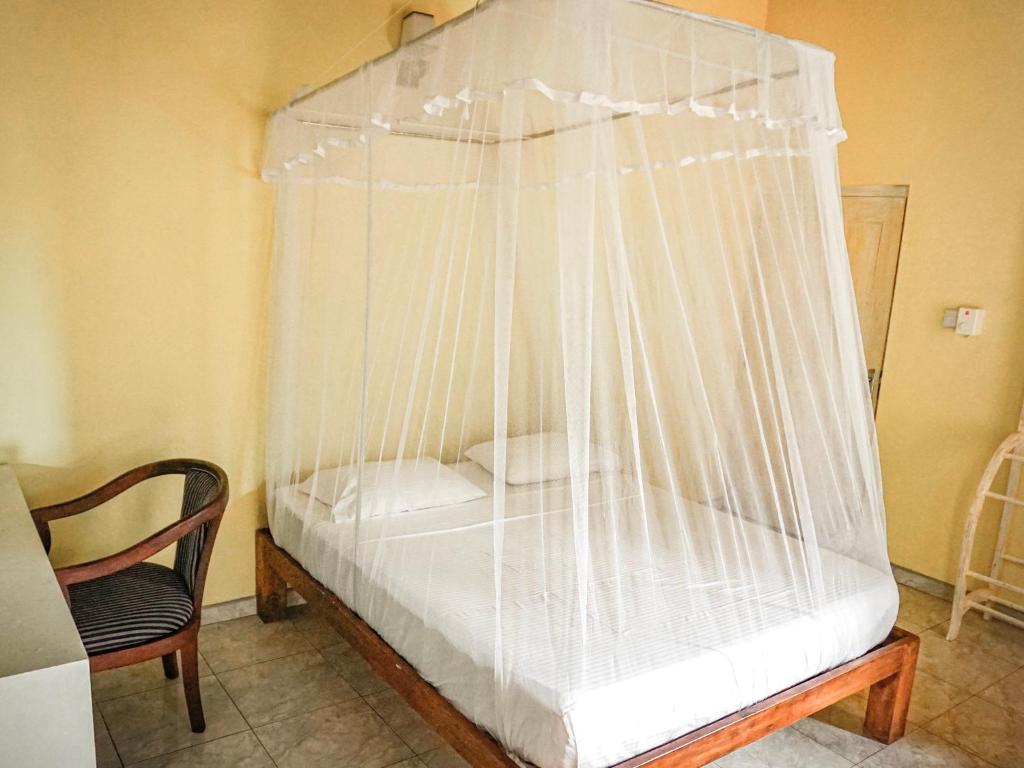 a bed with netting on it in a room at Nuga Eden Tangalle in Tangalle