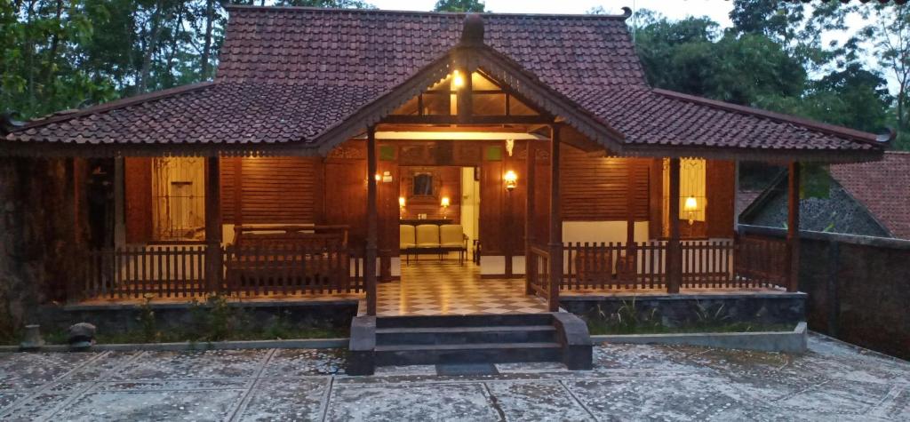 Cette petite maison en bois dispose d'une terrasse couverte et d'un escalier. dans l'établissement Griya Akbar, à Yogyakarta