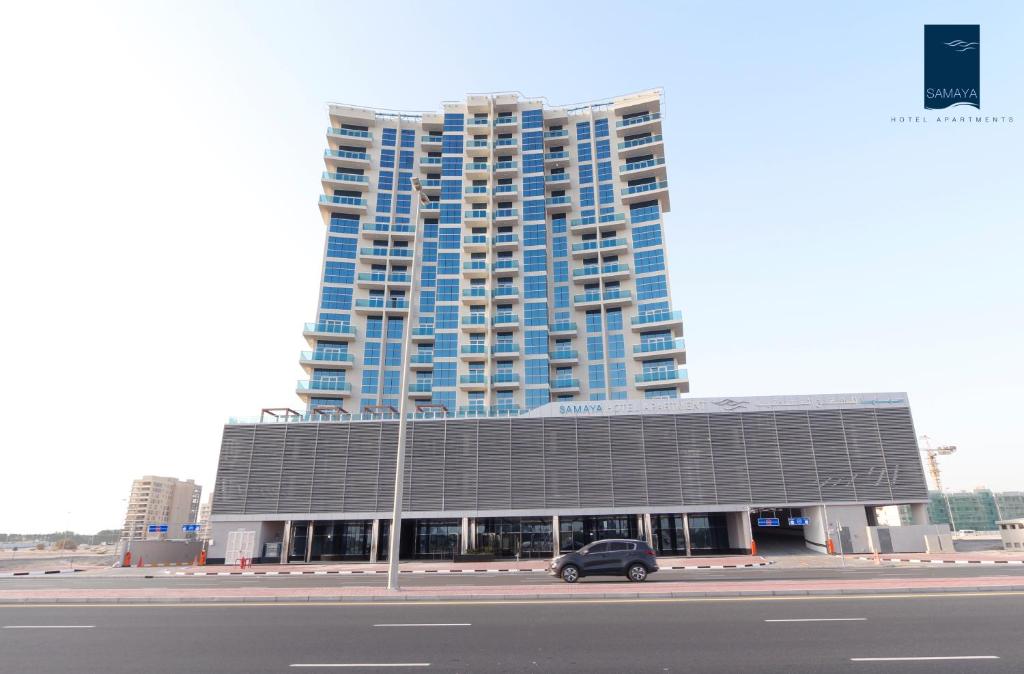 Samaya Hotel Apartment Dubai في دبي: سيارة متوقفة أمام مبنى كبير