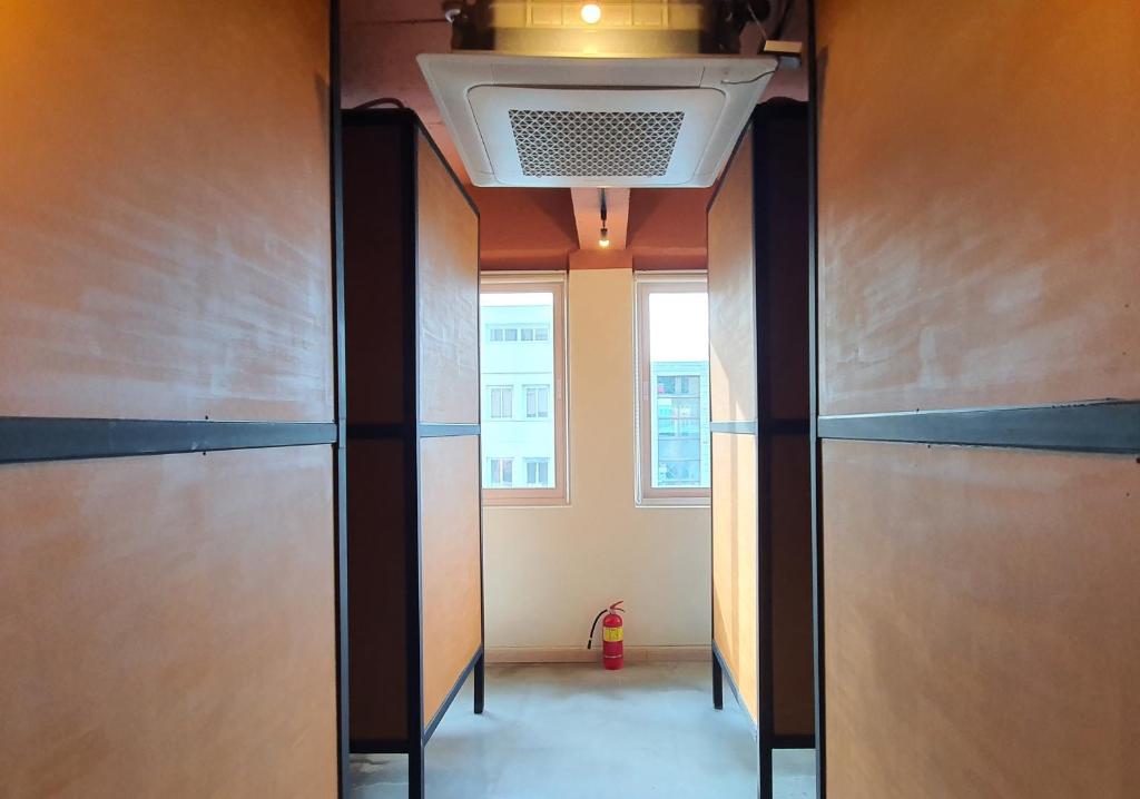 a hallway with two doors and a ceiling at 농땡이 연구소 Nonday Laboratory in Jeju