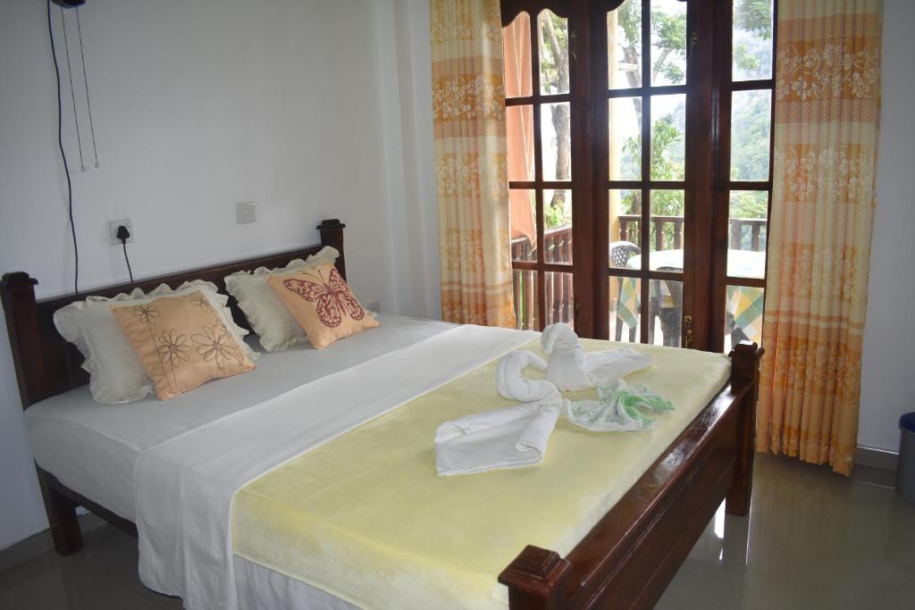 a bedroom with a bed with towels on it at Pasan Guest in Ella