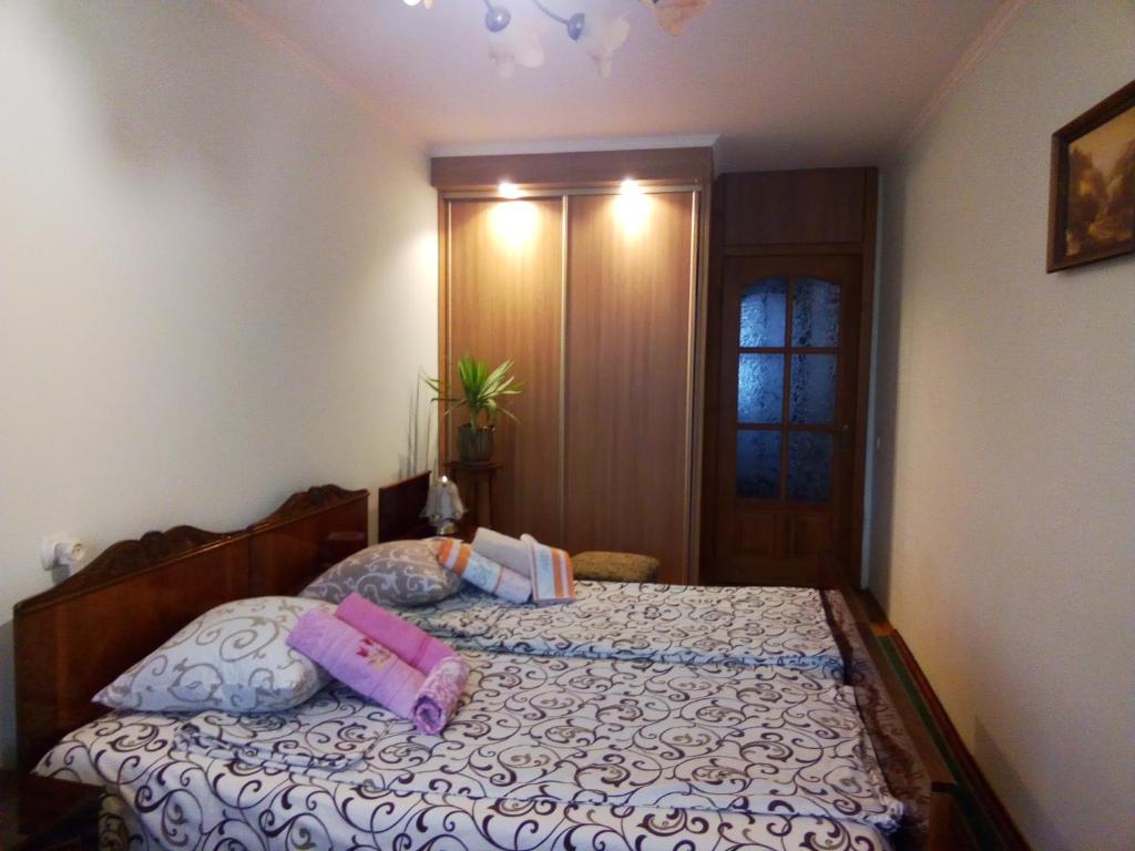 ein Schlafzimmer mit einem Bett mit Kissen darauf in der Unterkunft Apartments in Lviv in Lwiw