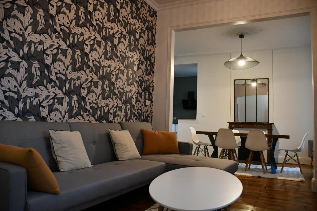 a living room with a couch and a table at Maison bourgeoise Haussmannienne - Gîtes de France in Limoges