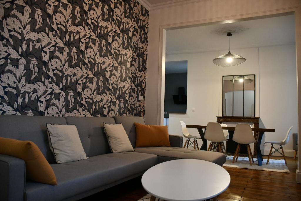 un soggiorno con divano e tavolo di Maison bourgeoise Haussmannienne - Gîtes de France a Limoges