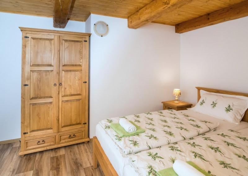 um quarto com uma cama e um armário de madeira em Penzion Konvalinka em Jimramovské Pavlovice