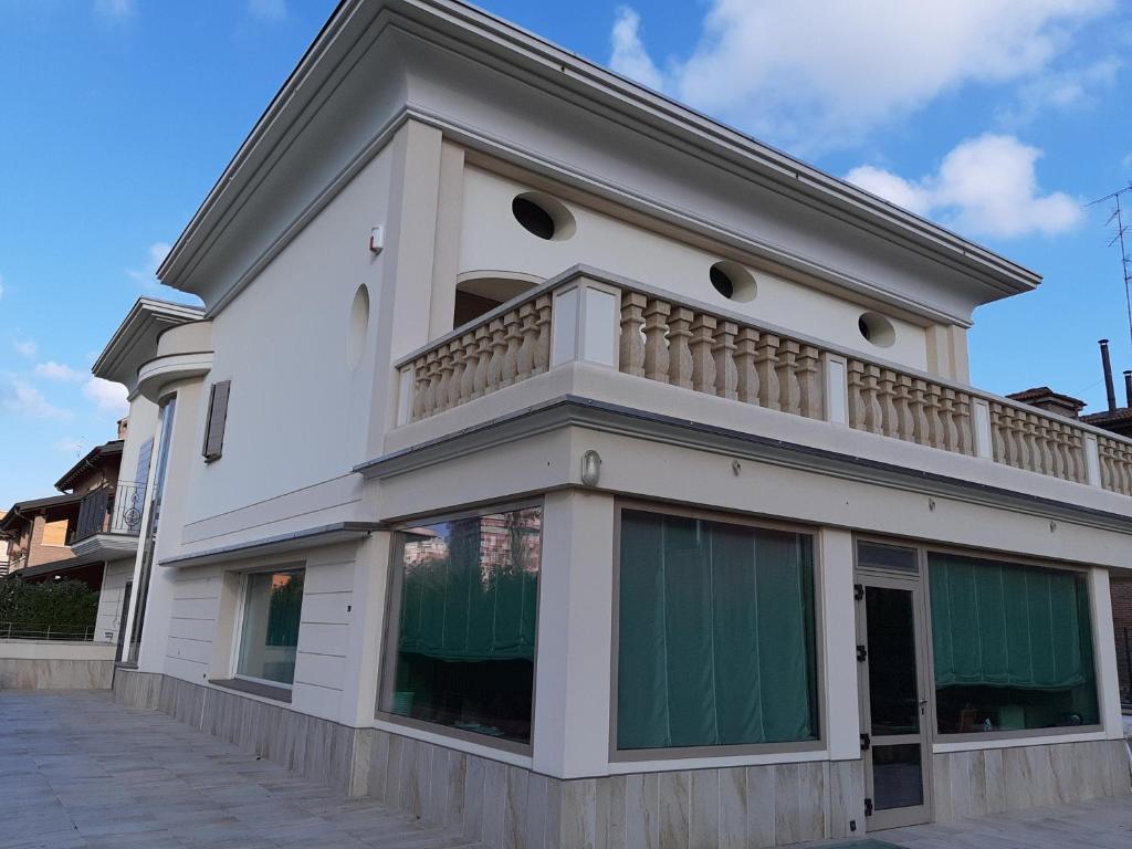 a white building with a balcony on top of it at La Dimora nel Parco in Modena