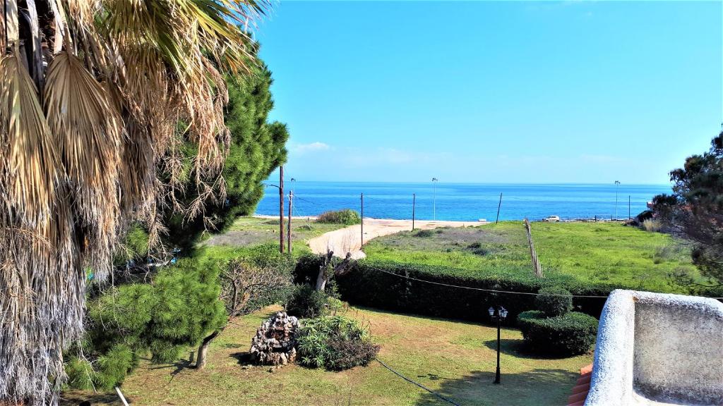 a view of the ocean from a hill with a beach at Vravrona Family House in Artemida