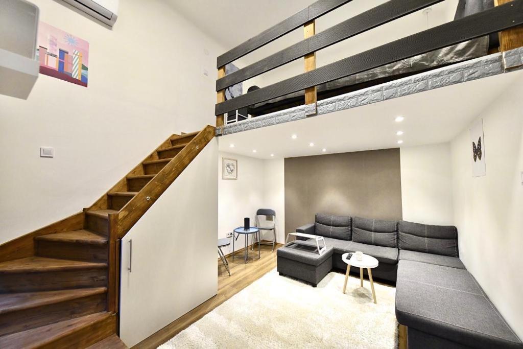 Apartamento tipo loft con escalera y sofá en Cosy flat in Király str, Queen en Budapest
