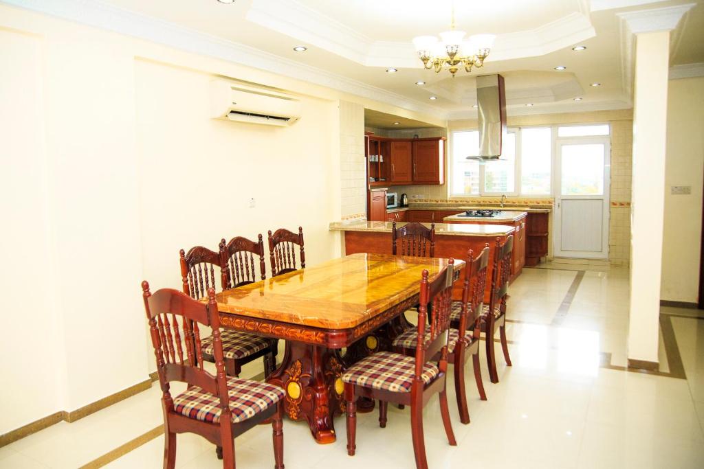 a kitchen with a wooden dining room table and chairs at Spacious Apartment near the Beach in Masaki in Dar es Salaam