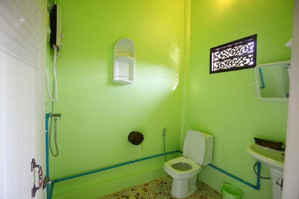 a green bathroom with a toilet and a sink at PP Red Tuna Hut in Phi Phi Don