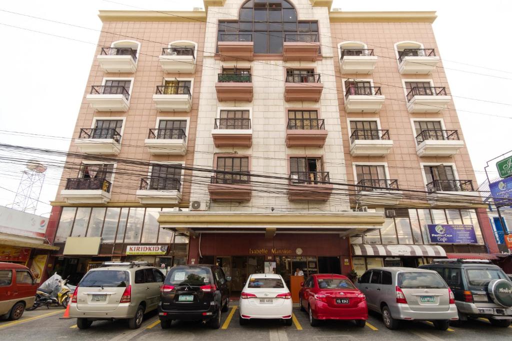 um edifício com carros estacionados em frente em RedDoorz Plus near Johnson and Johnson Paranaque em Manila