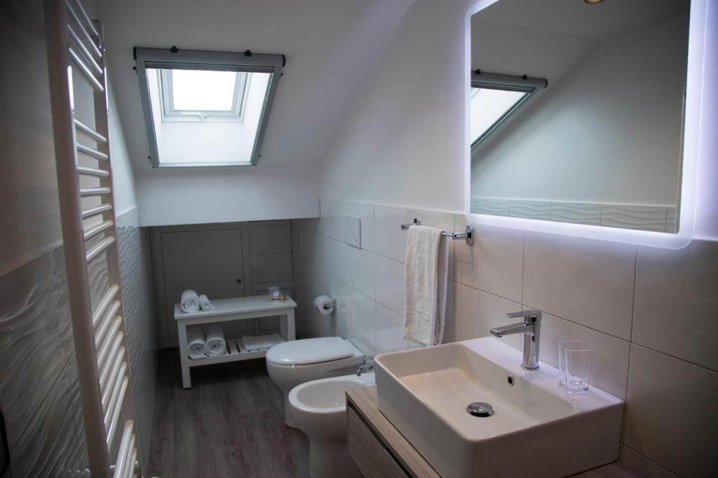 a white bathroom with a sink and a toilet at Etna Sunrise b&b in Zafferana Etnea