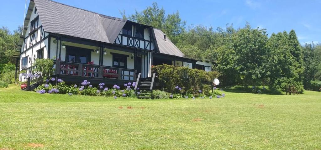 una grande casa con dei fiori davanti di Woodcutters Guest House a Haenertsburg