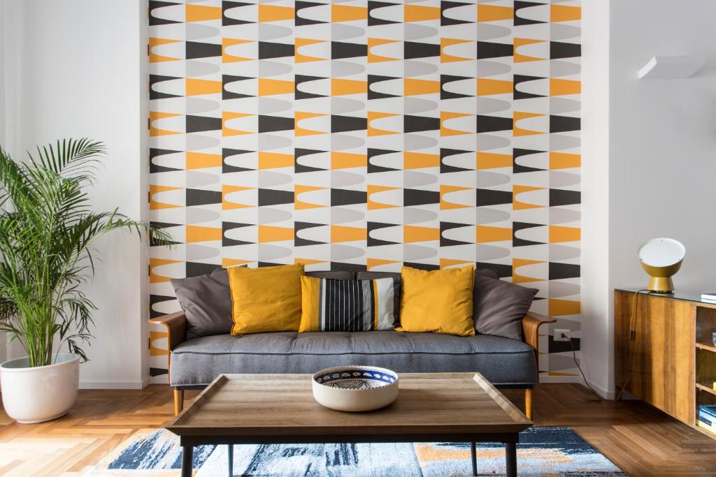 a living room with a couch and a geometric wall at Dimora Toledo in Naples