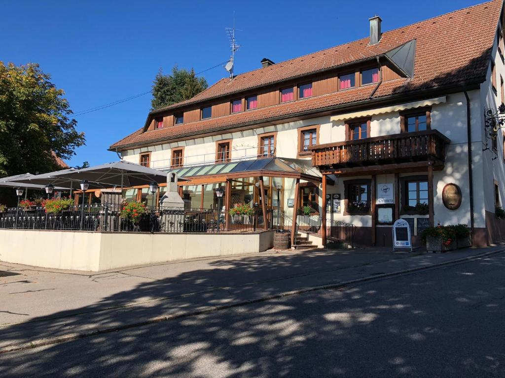 Gasthaus zum Ochsen في Herrischried: مبنى امامه طاولات ومظلات