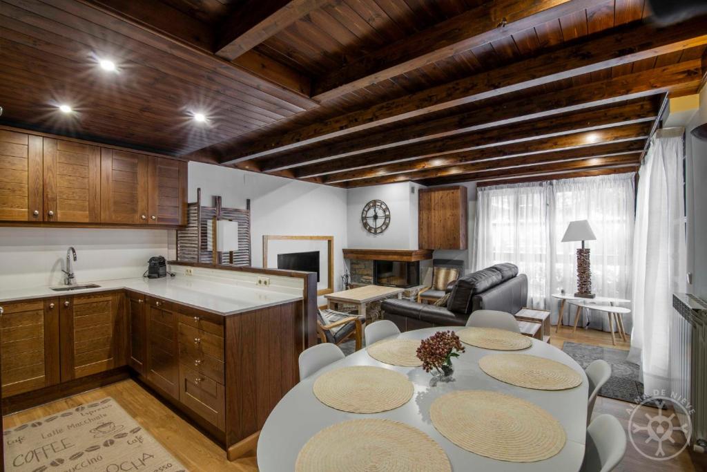 cocina y sala de estar con mesa y sillas en LOS CIERVOS de Alma de Nieve en Baqueira Beret