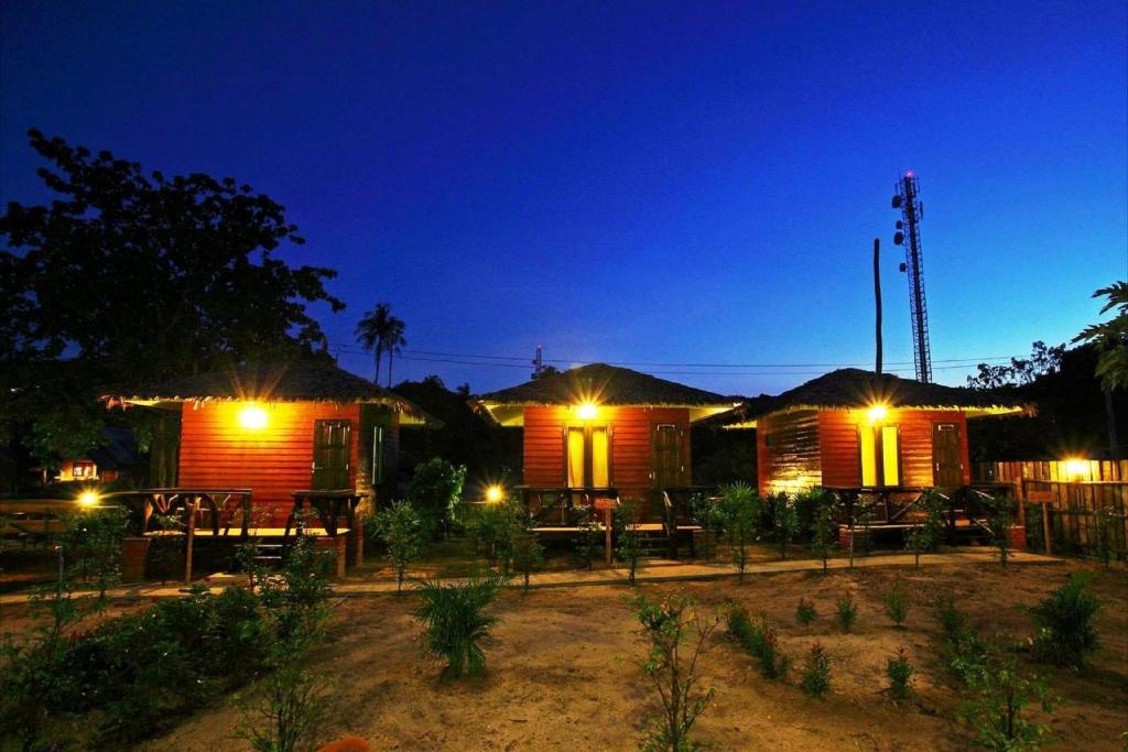 a couple of wooden houses with lights on them at PP Red Tuna Hut in Phi Phi Don