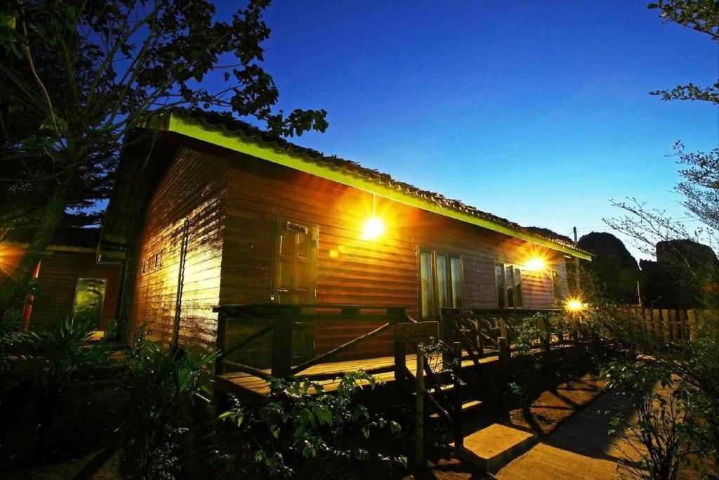a small wooden cabin with lights on it at night at PP Red Tuna Hut in Phi Phi Don
