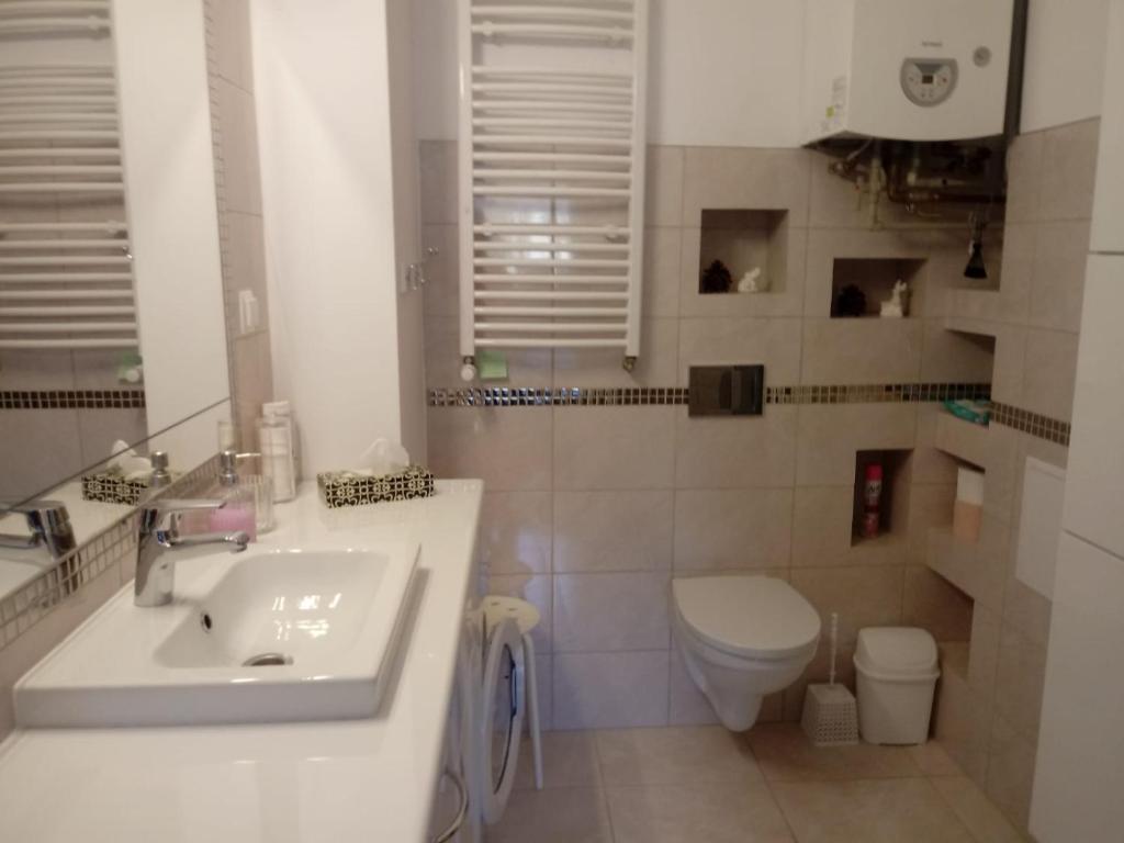 a white bathroom with a sink and a toilet at come&stay Zielona Góra in Zielona Góra